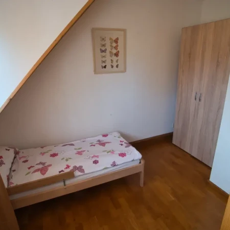 Familienfreundliches Schlafzimmer: Neben dem King-Size-Boxspringbett gibt es ein Kinderbett und einen Kleiderschrank