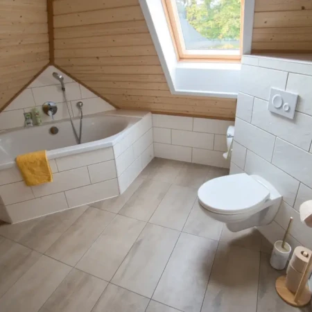 Das Badezimmer verbindet Funktionalität mit Komfort. Es verfügt über ein WC und eine großzügige Eckbadewanne, die zum Entspannen einlädt. Hier könnt ihr nach einem langen Tag abschalten und den Alltag hinter euch lassen.