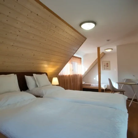 Das gemütliche Schlafzimmer bietet ein Kingsize-Boxspringbett für erholsamen Schlaf, ein Kinderbett für die Kleinen sowie einen praktischen Arbeitsplatz. Ein geräumiger Kleiderschrank und ein Smart-TV sorgen für zusätzlichen Komfort – ideal für zwei Erwachsene und ein Kind.
